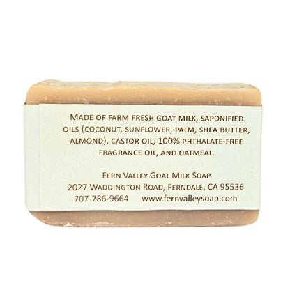 Bar of soap with a label detailing ingredients and contact information on a white background